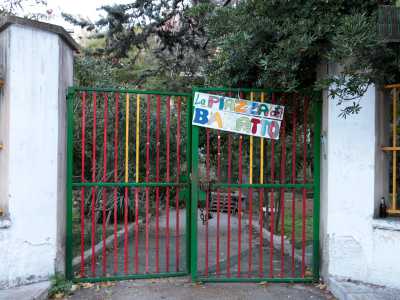 Varchiamo l'entrata, costituita da un cancello verde sul quale � affisso un cartellone variopinto con su scritto "La piazza del baratto": pubblicizza uno degli appuntamenti fissi organizzati dagli occupanti